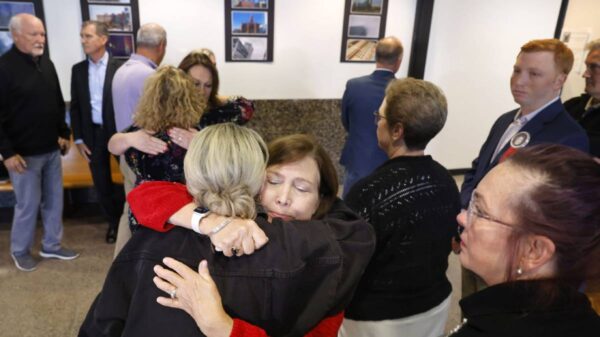 Loren Adair Smith (facing) receives a hug from Cheryl Pangburn