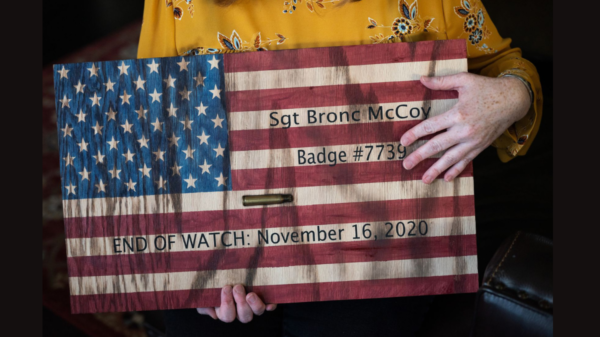 Katie McCoy holds a wooden American flag