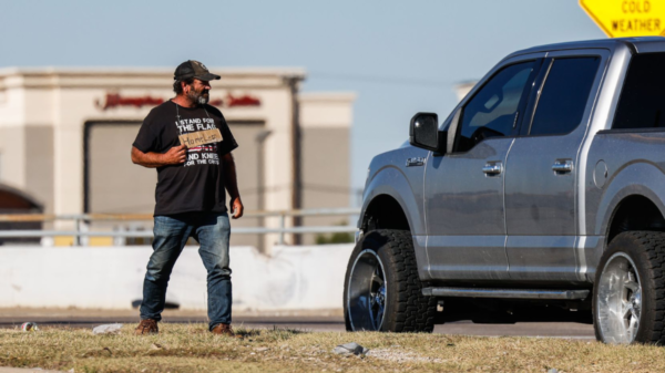 man stands on a median in Dallas soliciting